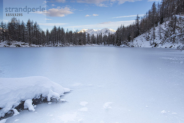 Blick auf den zugefrorenen Lago Azzurro  umgeben von Schnee in der Morgendämmerung  Splugatal  Provinz Sondrio  Valtellina  Lombardei  Italien  Europa