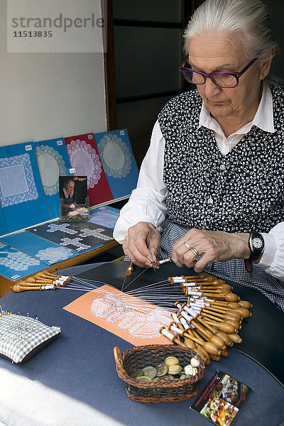 Alte Frau  die mit Stecknadeln und Klöppeln Spitzen von Hand herstellt  Brügge  Westflandern  Belgien  Europa