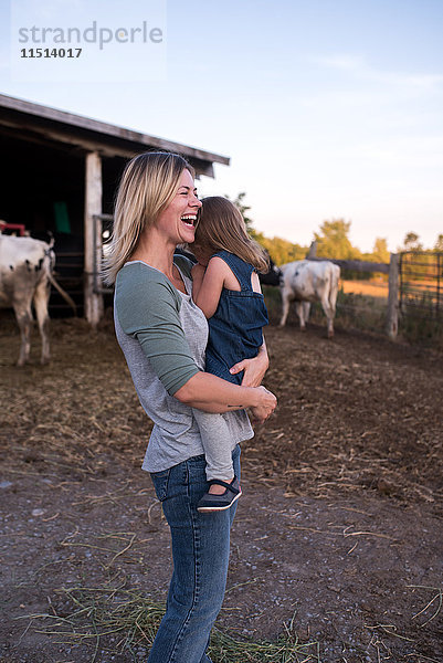 Mutter mit Tochter auf dem Bauernhof  Mutter lacht