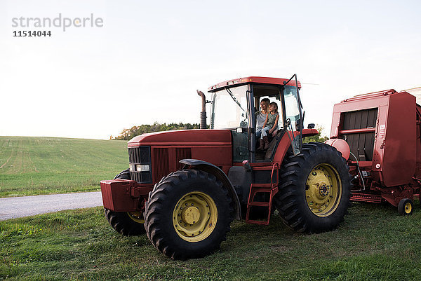Mutter und Tochter im Traktor sitzend