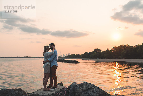 Romantisches Paar von Angesicht zu Angesicht auf einem Felsblock  Ontariosee  Toronto  Kanada