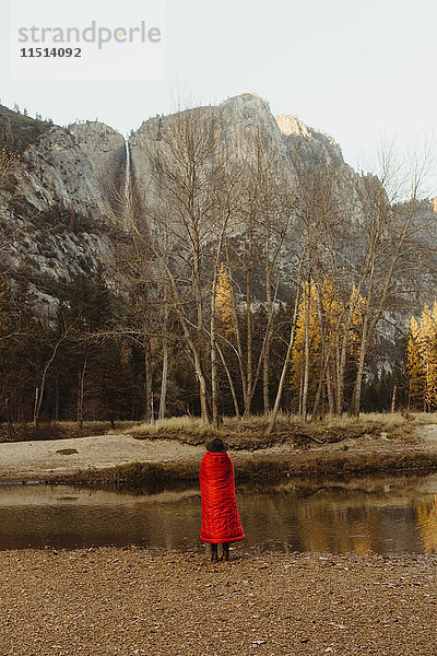 Rückansicht einer in eine rote Decke gehüllten Frau mit Blick auf den Berg  Yosemite National Park  Kalifornien  USA