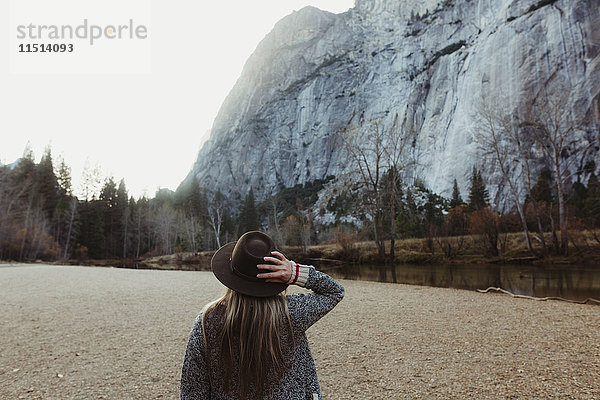 Rückansicht einer Frau mit Hut  die auf einen Berg schaut  Yosemite National Park  Kalifornien  USA
