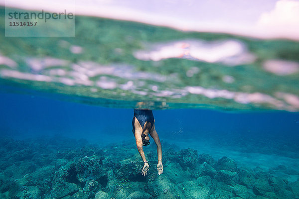 Unterwasseraufnahme einer Frau  die ins Wasser taucht  Oahu  Hawaii  USA