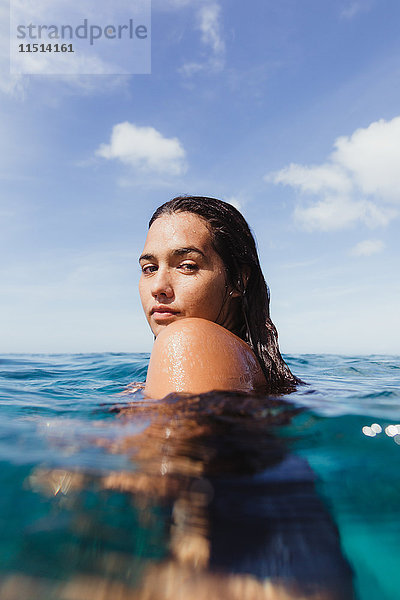 Frau im Meer  die vor der Kamera über die Schulter schaut  Oahu  Hawaii  USA