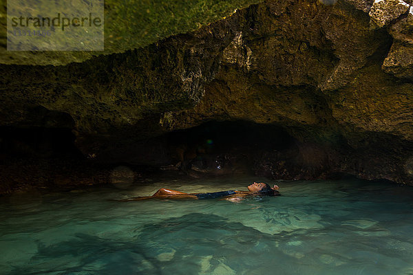 Frau schwimmt in wassergefüllter Höhle  Oahu  Hawaii  USA