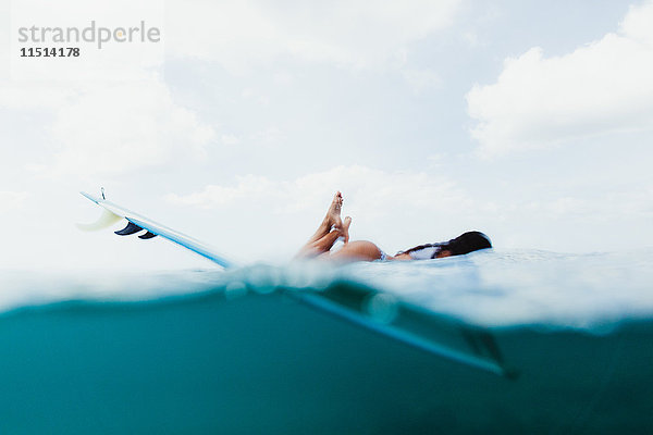 Oberflächenansicht einer auf einem Surfbrett liegenden Frau  Oahu  Hawaii  USA