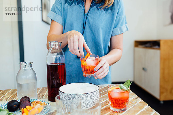 Frau bereitet Cocktail zu