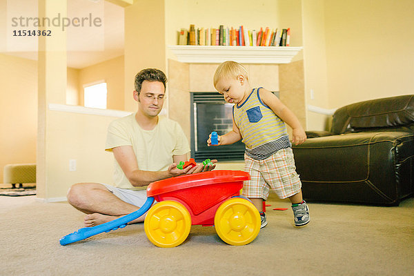 Vater und kleiner Sohn spielen zu Hause zusammen