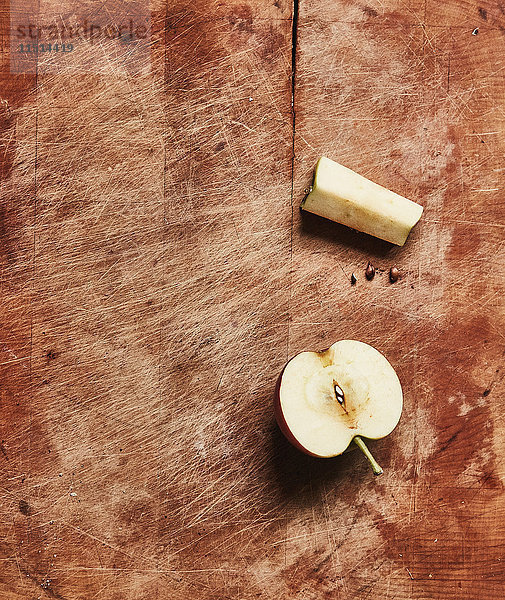 Draufsicht auf frisch halbierten Apfel und Apfelkern auf Holzschneidebrett