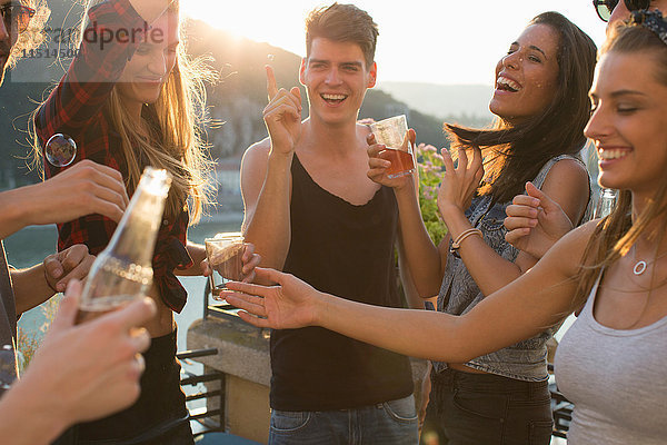 Erwachsene Freunde feiern auf der Dachterrasse am Wasser  Budapest  Ungarn