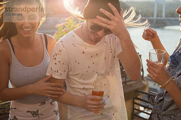 Junges Paar bei windiger Dachterrassenparty am Wasser  Budapest  Ungarn