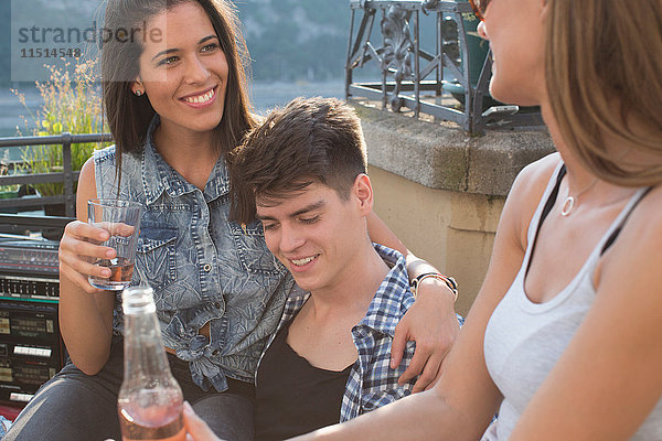 Drei erwachsene Freunde entspannen sich bei einer Dachterrassenparty  Budapest  Ungarn