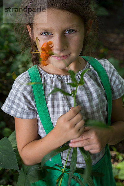 Porträt eines jungen Mädchens  das eine Blume hält