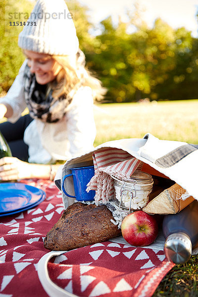 Junge Frau beim Picknick im Park liegend