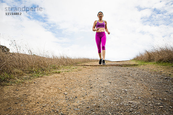 Weibliche Läuferin läuft auf unbefestigter Strecke