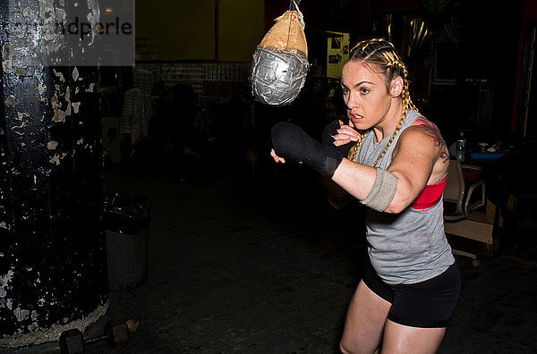 Boxerinnen trainieren im Fitnessstudio  Boxball schlagend