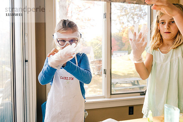 Zwei Mädchen beim wissenschaftlichen Experiment  die große Latexhandschuhe anziehen