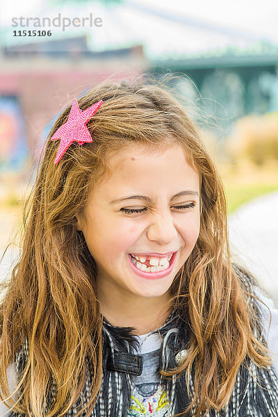 Bildnis eines Mädchens mit langem braunem gewelltem Haar beim Lachen