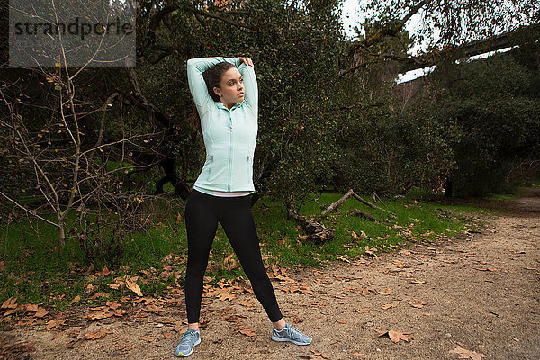 Junge Frau beim Sport  beim Stretching  im Freien