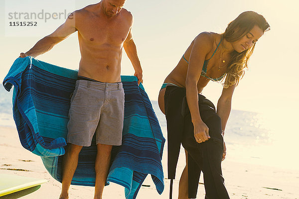 Surferpaar zieht Neoprenanzug an Newport Beach  Kalifornien  USA  an