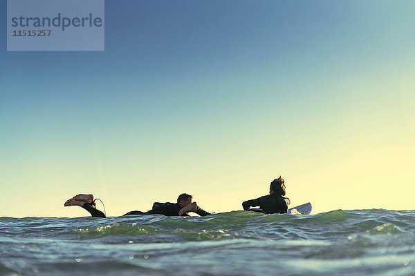 Surferpaar paddelt mit Surfbrettern auf See  Newport Beach  Kalifornien  USA