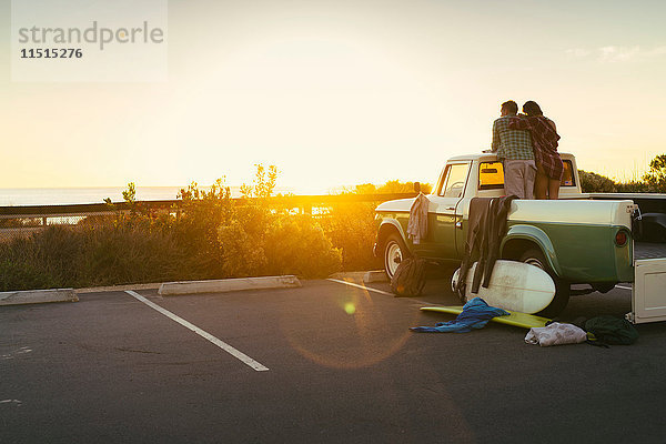 Rückansicht eines Paares hinten im Pick-up  das den Sonnenuntergang in Newport Beach  Kalifornien  USA  beobachtet