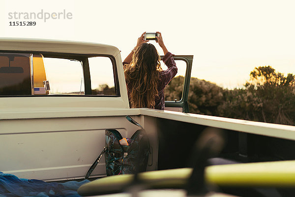 Rückansicht einer jungen Frau mit Pickup-Truck beim Fotografieren der Küste von Newport Beach  Kalifornien  USA