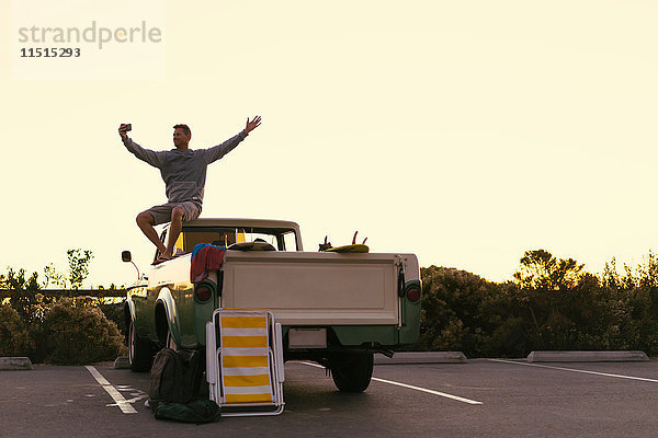 Mann nimmt Smartphone-Selfie auf dem Rücksitz eines Pickup-Trucks in Newport Beach  Kalifornien  USA