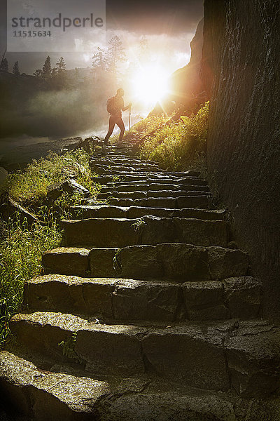 Entfernter Wanderer auf Steintreppe bei Sonnenuntergang