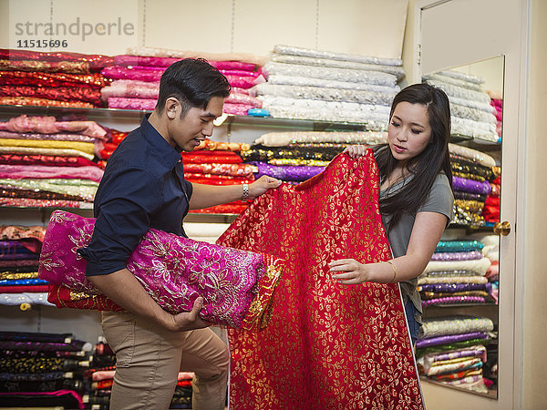 Chinesischer Mann und Frau beim Einkaufen von Stoffen