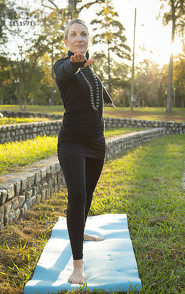 Kaukasische Frau übt Yoga im Park