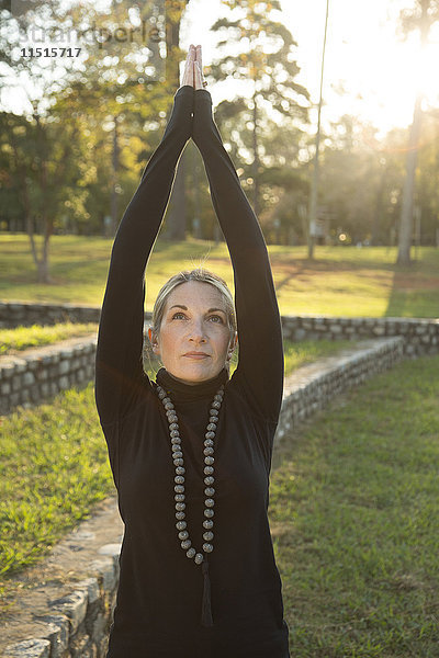 Kaukasische Frau übt Yoga im Park