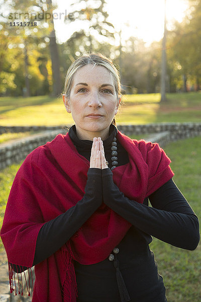 Porträt einer kaukasischen Frau beim Meditieren im Park