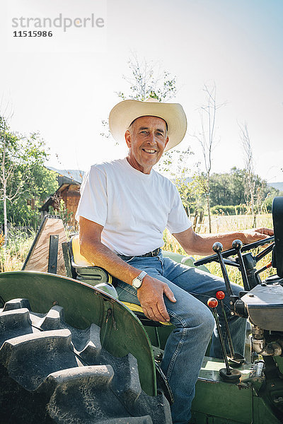 Kaukasischer Bauer auf Traktor sitzend