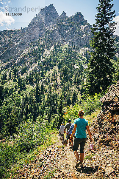 Kaukasische Menschen wandern auf einem Pfad in den Bergen