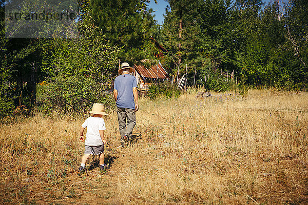 Kaukasischer Großvater und Enkel gehen im Feld spazieren