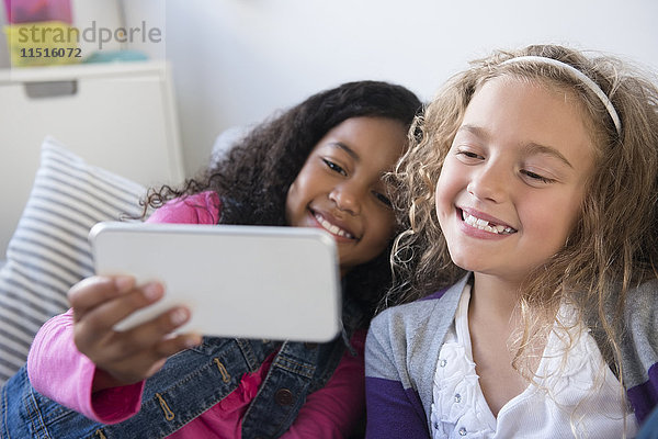 Lächelnde Mädchen posieren für Handy-Selfie