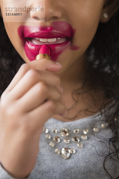 Mixed Race Mädchen trägt unordentlichen Lippenstift auf