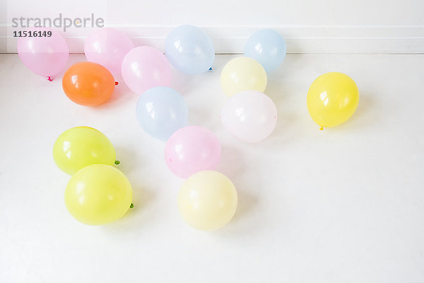Mehrfarbige Luftballons auf weißem Boden