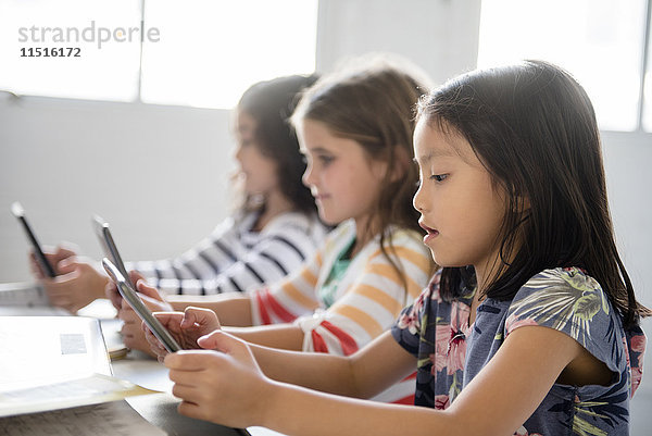 Mädchen nutzen digitale Tablets im Klassenzimmer