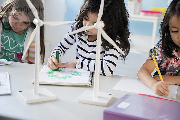 Mädchen lernen im Klassenzimmer über Windmühlen und Recycling