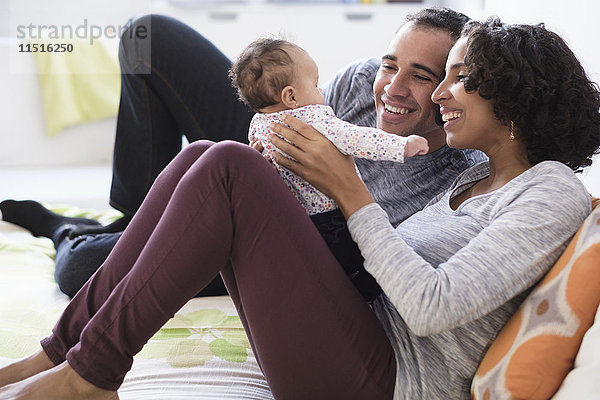 Hispanische Mutter und Vater spielen mit ihrer kleinen Tochter