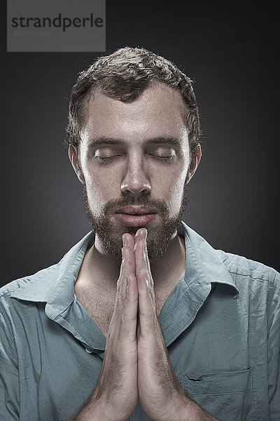 Ernster Mann  der mit geschlossenen Augen betet
