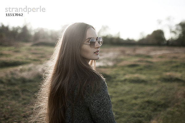 Kaukasische Frau mit Sonnenbrille auf einem Feld