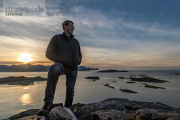 Mann besteigt im Herbst einen Gipfel auf der Insel Kvaloya  Arktis Norwegen