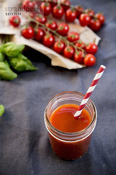 Tomatensaft in einem Glas mit einem Strohhalm