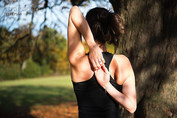 Frau macht am Herbsttag Yoga im Park