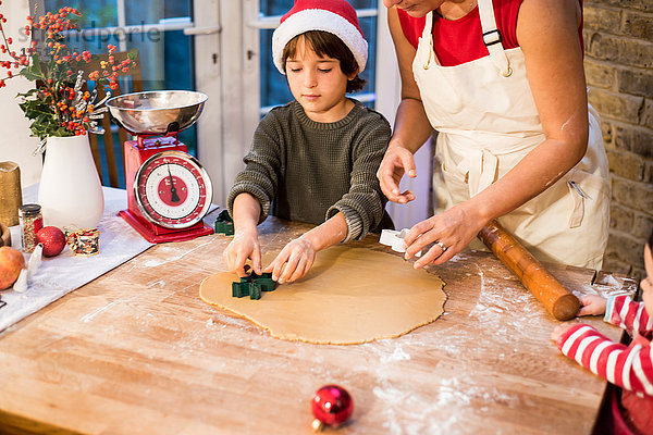 Mutter und Sohn backen zu Hause Weihnachtsplätzchen