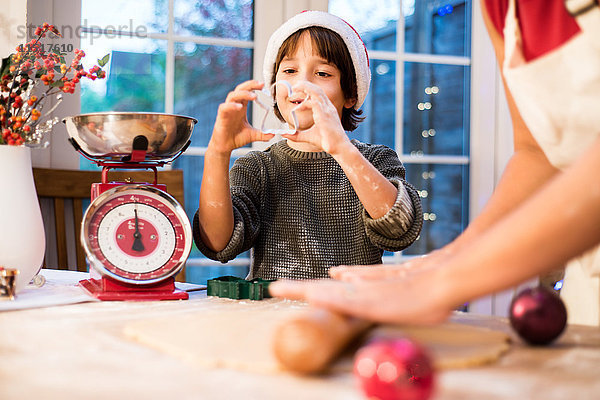 Mutter und Sohn backen zu Hause Weihnachtsplätzchen